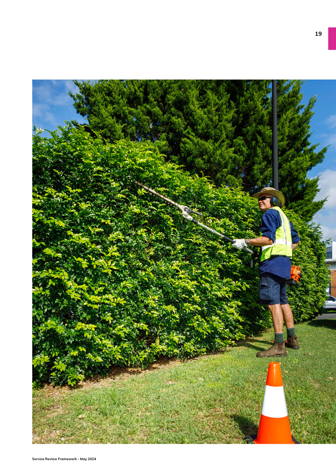 A person cutting bushes with a pair of scissors

Description automatically generated